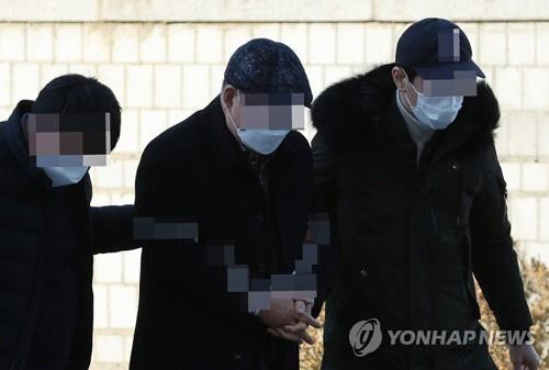 대검찰청 앞에 놓인 윤석열 전 검찰총장에 대한 응원 화환에 불을 지른 혐의(일반물건방화)로 기소된 문모(가운데) 씨가 지난 1월 7일 구속 전 피의자심문(영장실질심사)에 출석하는 모습. [연합뉴스 자료사진]